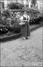 Retrato de uma mulher com vestuário tradicional num jardim de uma unidade hoteleira não identificada 