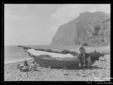 Homem sentado num barco de pesca na praia do Vigário, Freguesia e Concelho de Câmara de Lobos