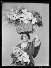 Retrato de uma florista com um cesto com flores na cabeça