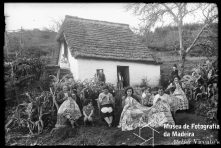 Bordadeiras em frente a uma casa de tipologia tradicional, em local não identificado, na Ilha da Madeira